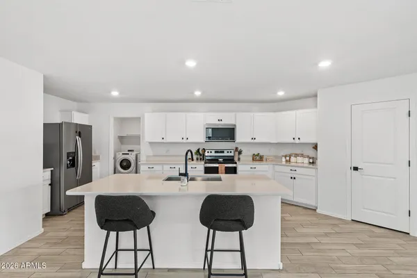 a kitchen with stainless steel appliances kitchen island granite countertop a refrigerator and a stove top oven