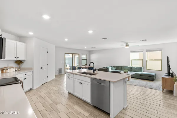 a kitchen with granite countertop a sink stove top oven and cabinets