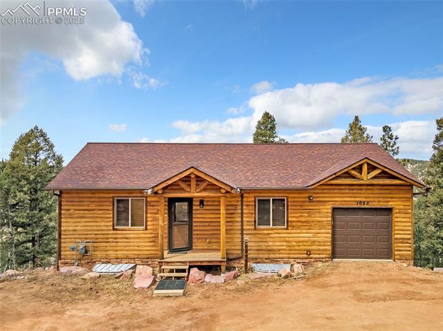 1055 Timber Ridge Road Divide, CO 80814 - Photo 37 of 47 View of front of home featuring driveway, a shingled roof, and an attached garage