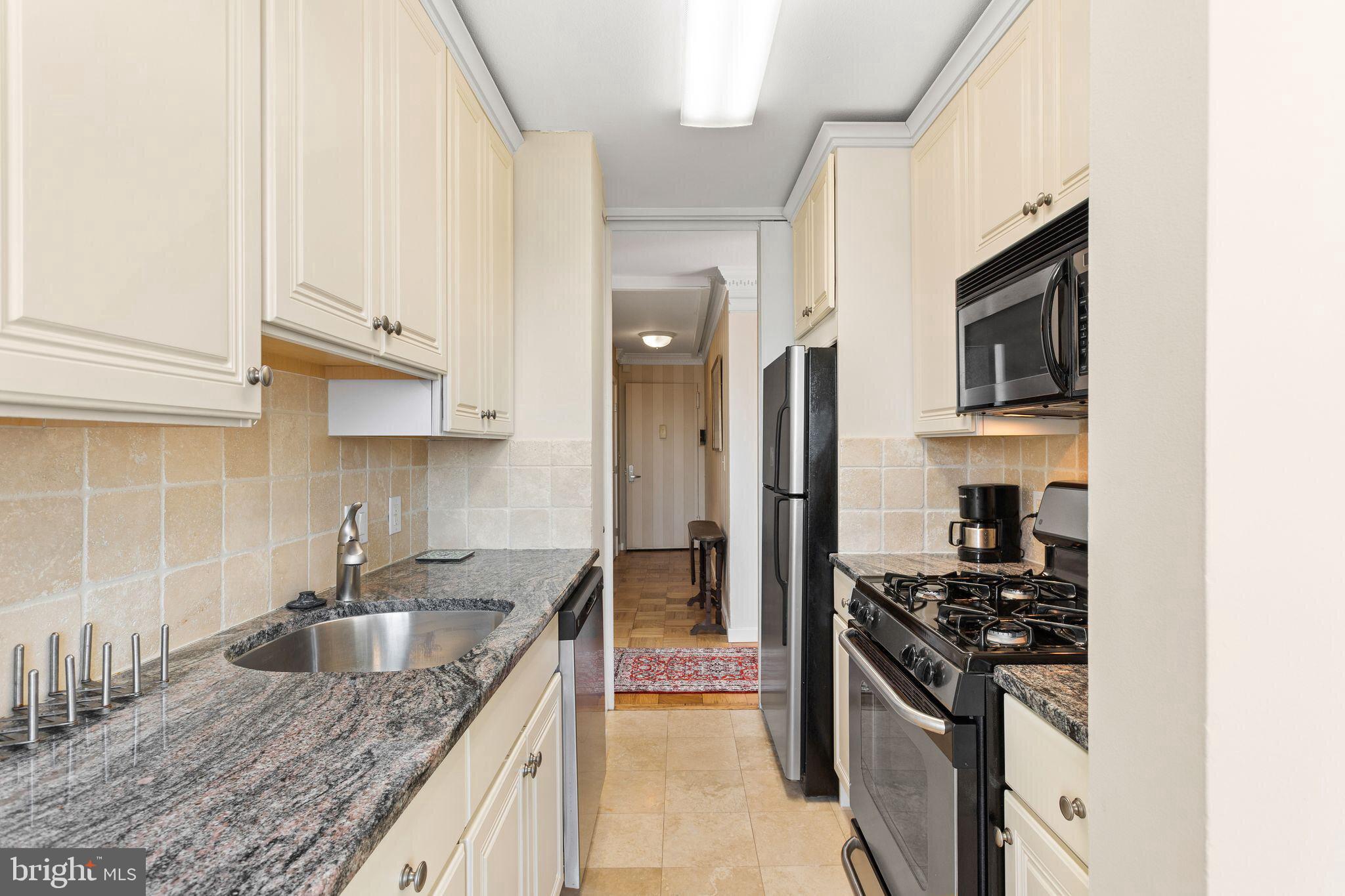 200 Locust Street, Unit 29AN Philadelphia, PA 19106 - Photo 15 of 58 a kitchen with granite countertop a sink stove and refrigerator