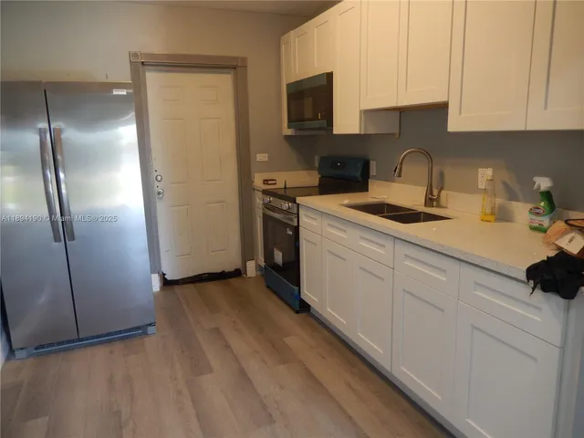 a kitchen with stainless steel appliances granite countertop a refrigerator sink and stove