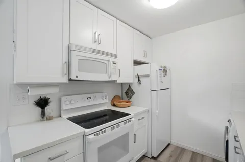 a kitchen with stainless steel appliances granite countertop white cabinets and a stove