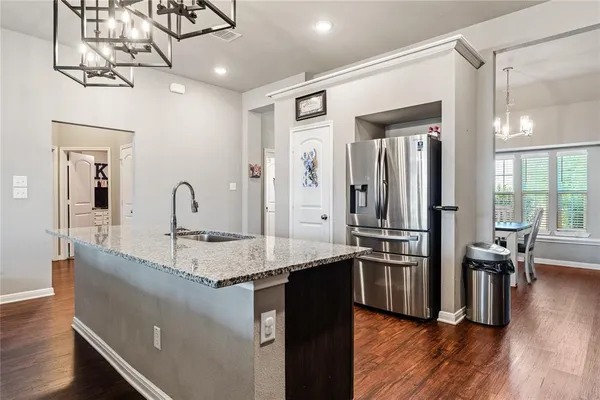 a kitchen with stainless steel appliances granite countertop a sink refrigerator and stove