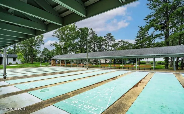 a view of swimming pool with lawn chairs and plants