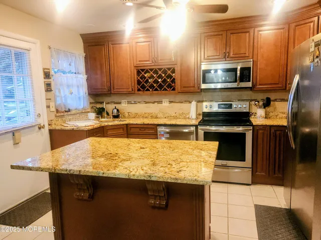 a kitchen with stainless steel appliances granite countertop a sink stove and microwave
