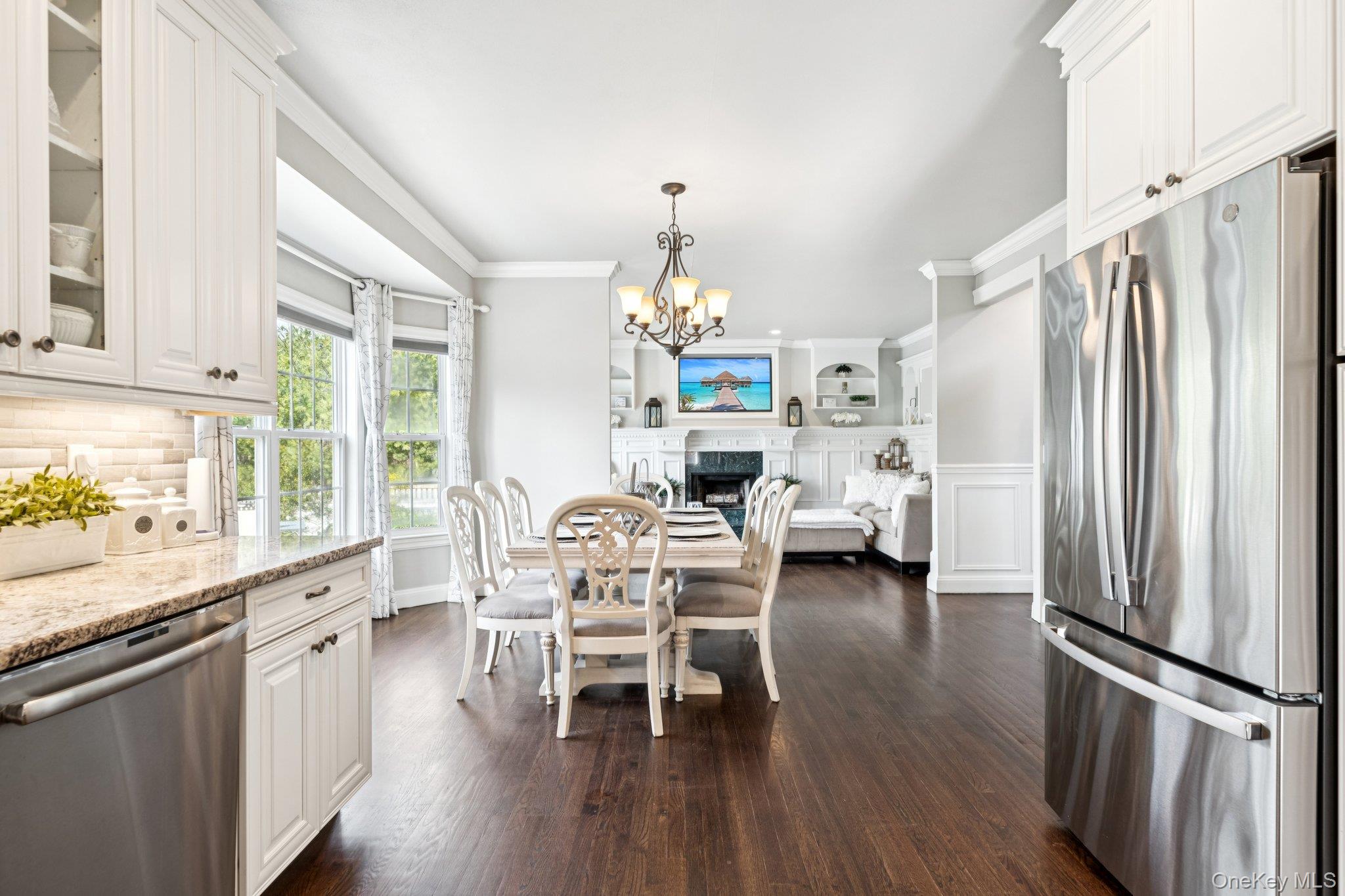 7 Brittany Court Ridge, NY 11961 - Photo 20 of 45 Dining room featuring a fireplace, a chandelier, dark wood-style floors, and crown molding
