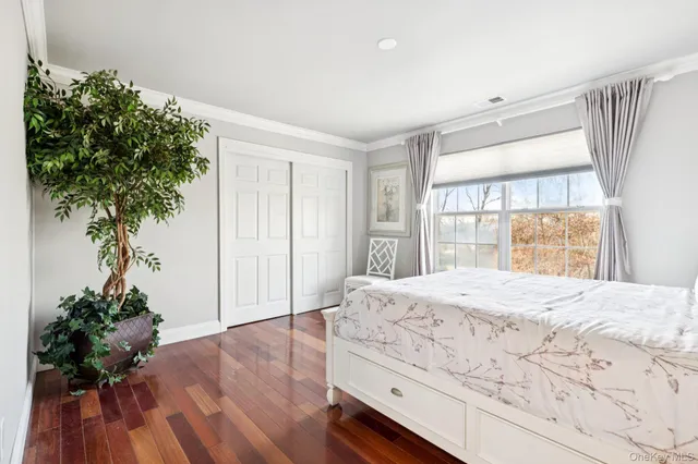 a bedroom with a bed and a potted plant
