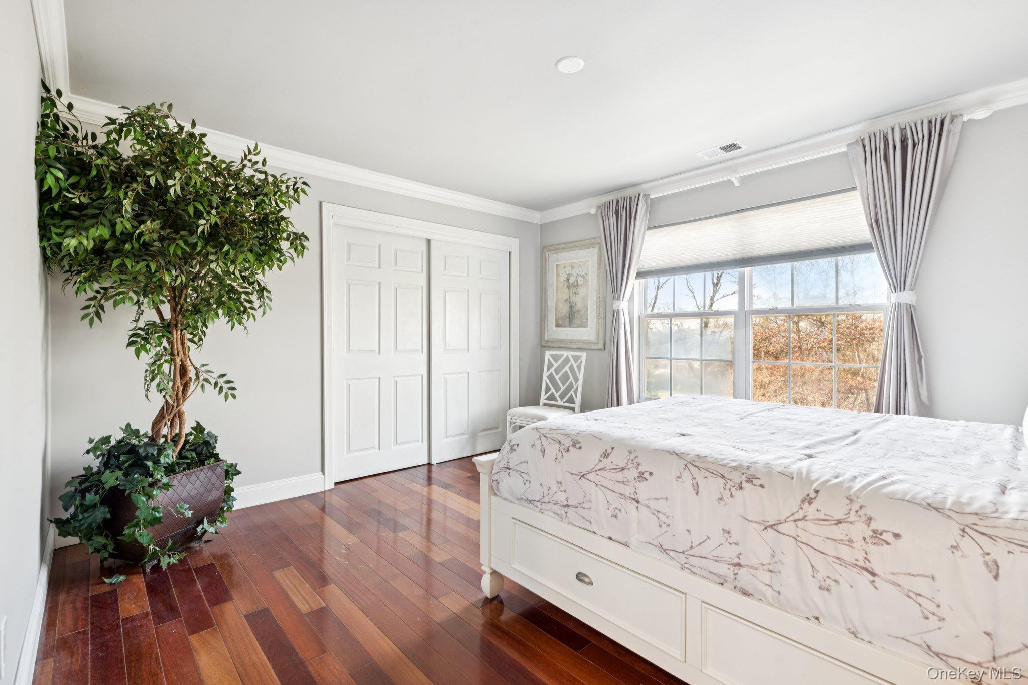 7 Brittany Court Ridge, NY 11961 - Photo 27 of 45 Bedroom with crown molding, dark wood finished floors, and a closet