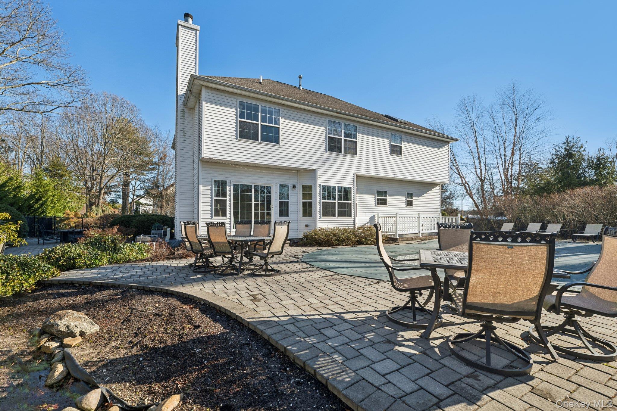 7 Brittany Court Ridge, NY 11961 - Photo 36 of 45 Back of house with a chimney, a patio area, and outdoor dining area