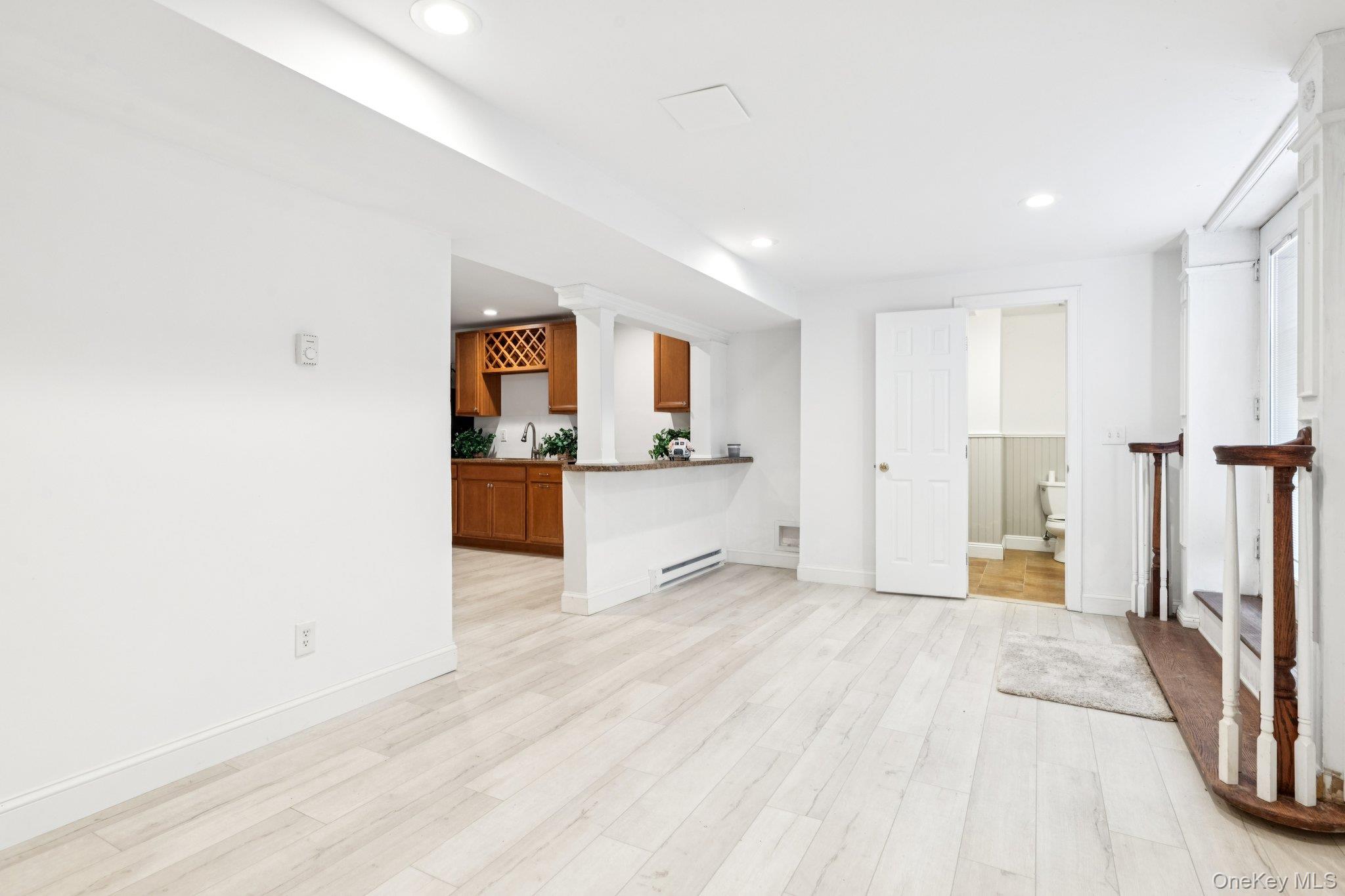 7 Brittany Court Ridge, NY 11961 - Photo 43 of 45 Unfurnished living room with light wood-style flooring, a baseboard heating unit, and recessed lighting