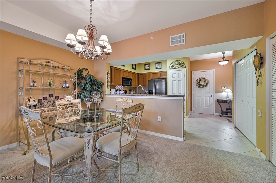 20201 Estero Gardens Circle, Unit 103 Estero, FL 33928 - Photo 12 of 33 a view of a dining room with furniture and chandelier