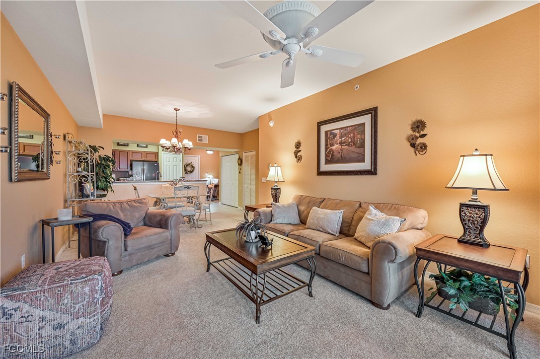 20201 Estero Gardens Circle, Unit 103 Estero, FL 33928 - Photo 15 of 33 a living room with furniture and a lamp