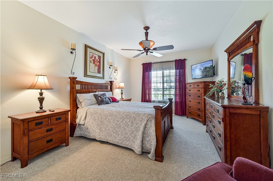 20201 Estero Gardens Circle, Unit 103 Estero, FL 33928 - Photo 21 of 33 a spacious bedroom with a bed and a flat tv screen on dresser