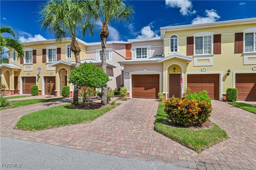 20201 Estero Gardens Circle, Unit 103 Estero, FL 33928 - Photo 4 of 33 a front view of a house with yard and green space