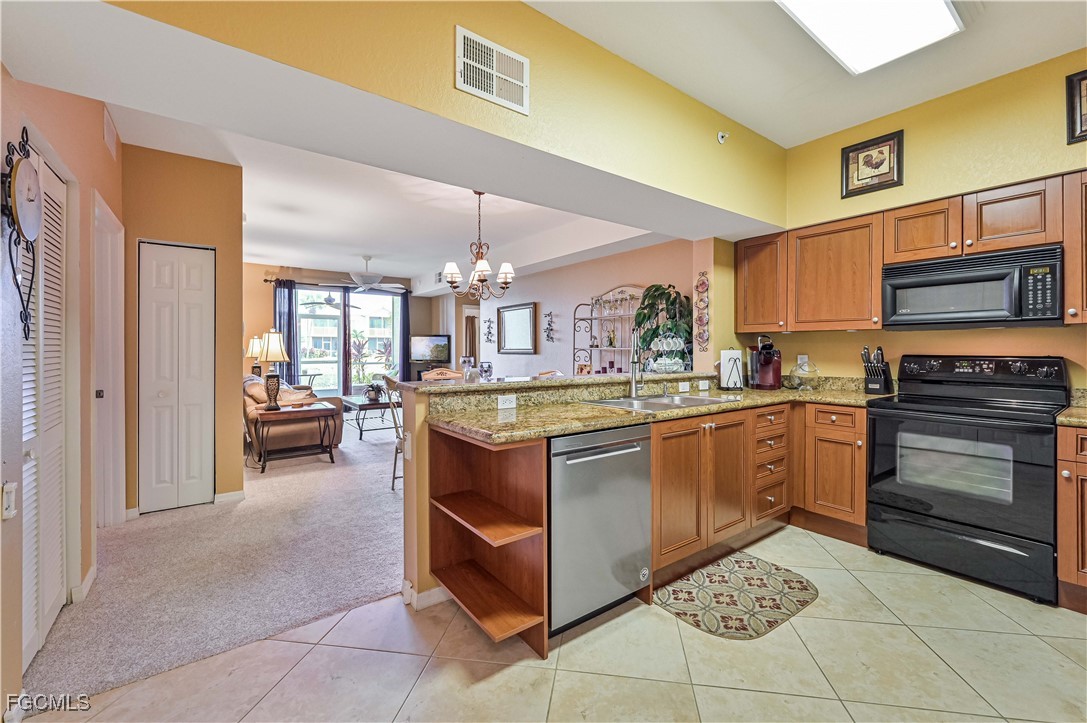 20201 Estero Gardens Circle, Unit 103 Estero, FL 33928 - Photo 8 of 33 a kitchen with stainless steel appliances granite countertop a stove and a sink