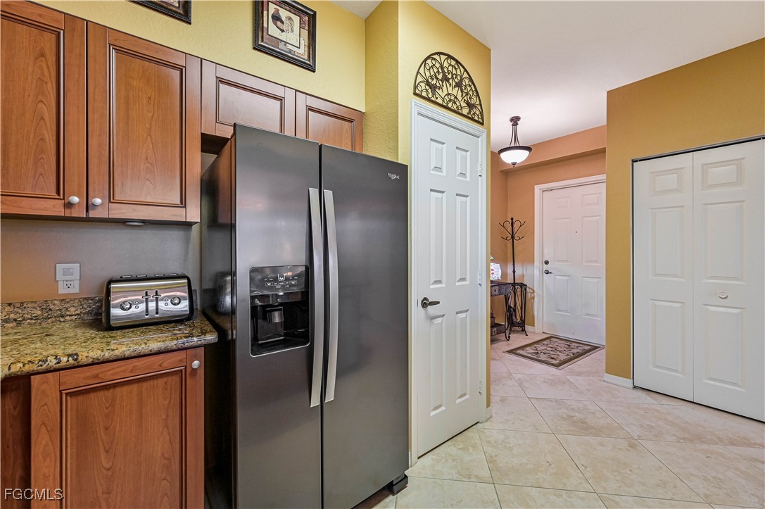 20201 Estero Gardens Circle, Unit 103 Estero, FL 33928 - Photo 10 of 33 a kitchen with stainless steel appliances granite countertop a refrigerator a stove and a sink