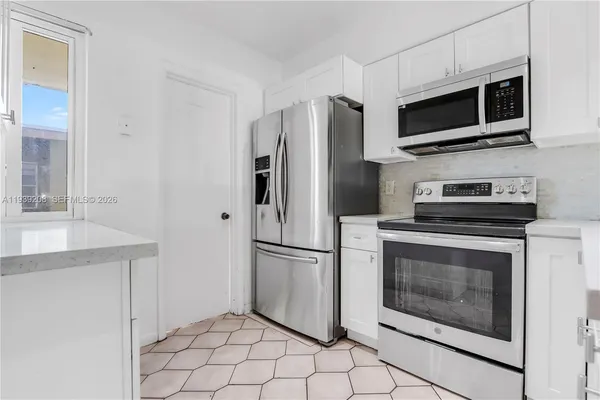 a kitchen with stainless steel appliances a stove a microwave and a refrigerator