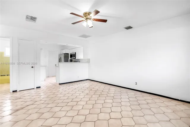 a view of a livingroom with a chandelier fan and wooden floor