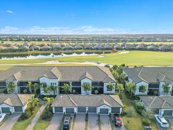 an aerial view of residential houses with outdoor space and ocean view