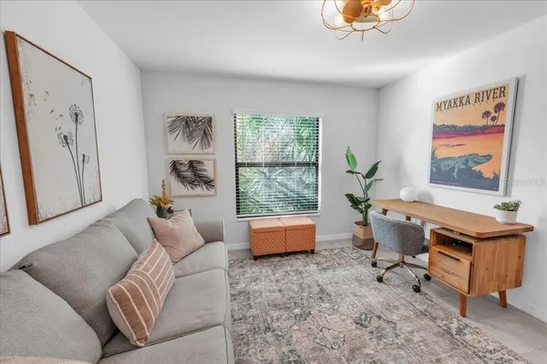 a living room with patio furniture and a clock