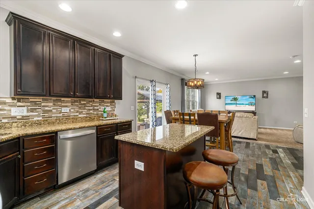 a kitchen with granite countertop sink cabinets dining table and chairs