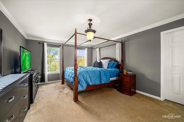 a bedroom with a bed and a flat tv screen on dresser