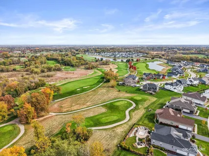 an aerial view of a residential houses with outdoor space and trees
