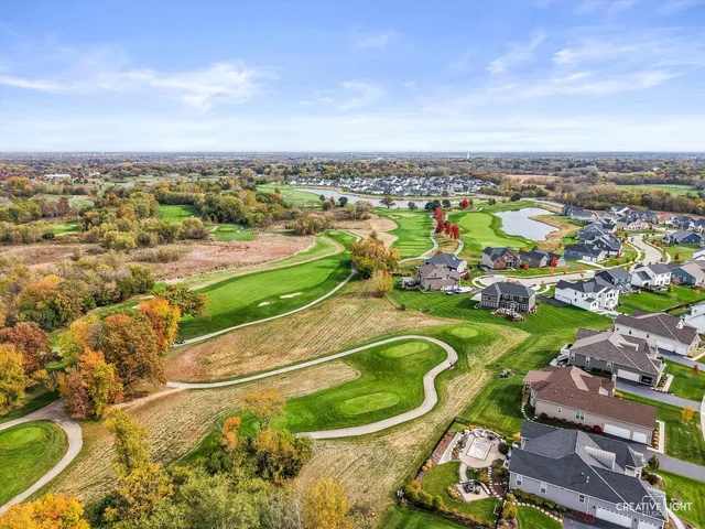 an aerial view of a residential houses with outdoor space and trees