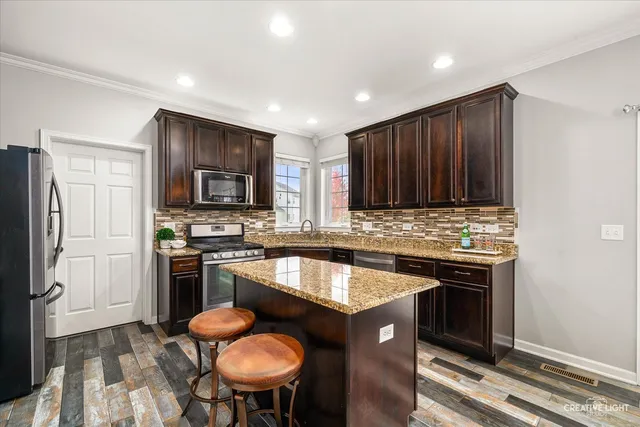 a kitchen with granite countertop a sink stove and refrigerator