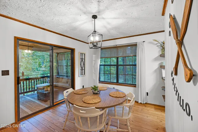 a dining room with furniture a chandelier and wooden floor