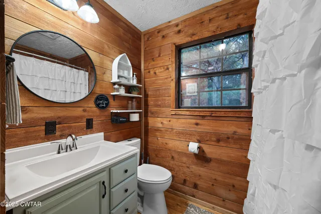 a bathroom with a granite countertop toilet sink and mirror