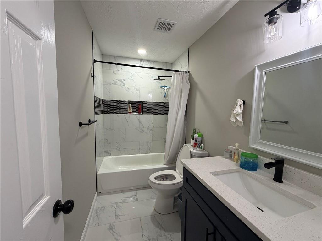 934 Bay Ridge Drive Lawrenceville, GA 30045 - Photo 37 of 78 a bathroom with a sink a toilet a mirror and shower