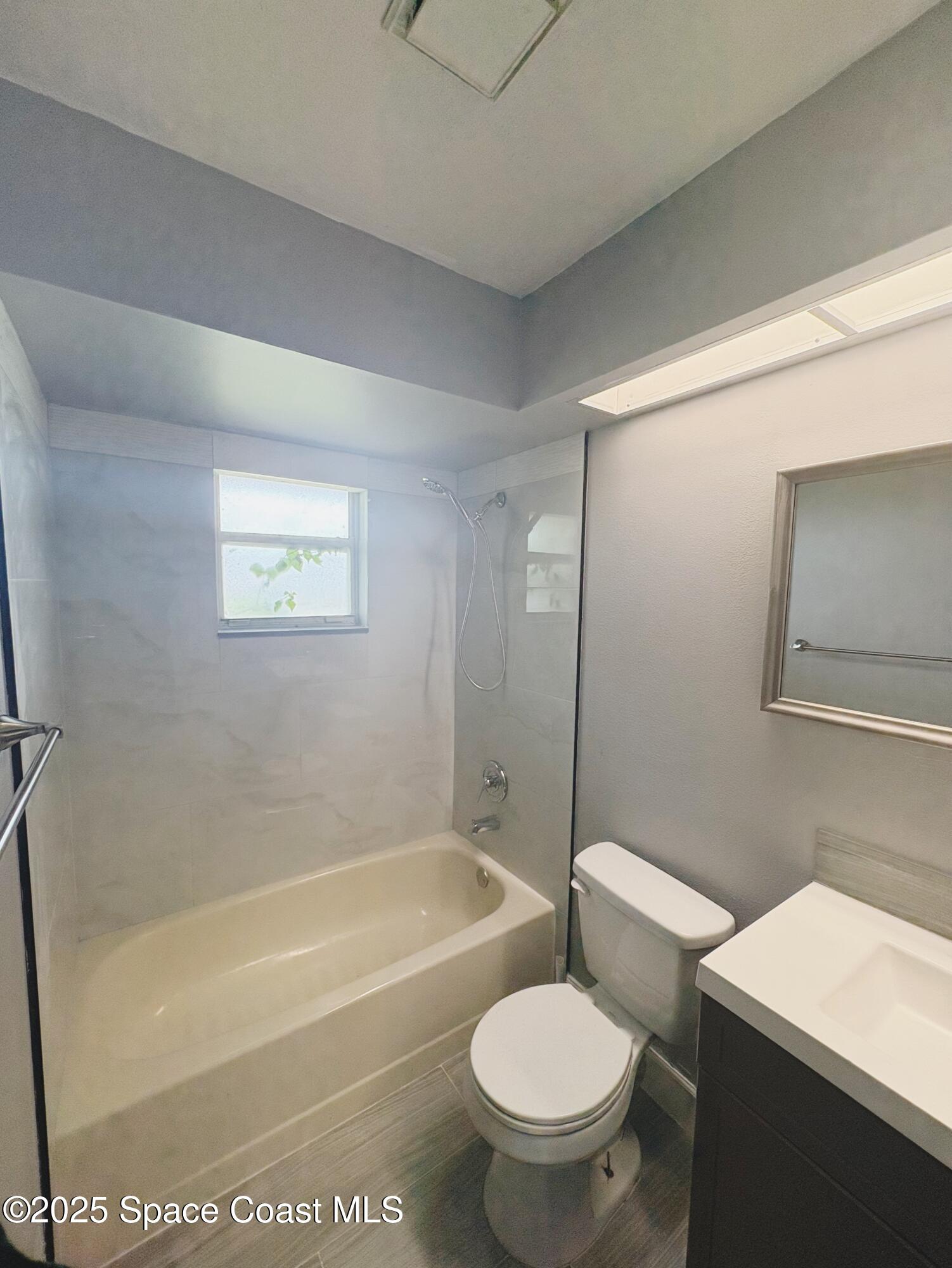 704 Cavio Avenue Northeast Palm Bay, FL 32905 - Photo 12 of 17 a bathroom with a toilet a sink and a bathtub