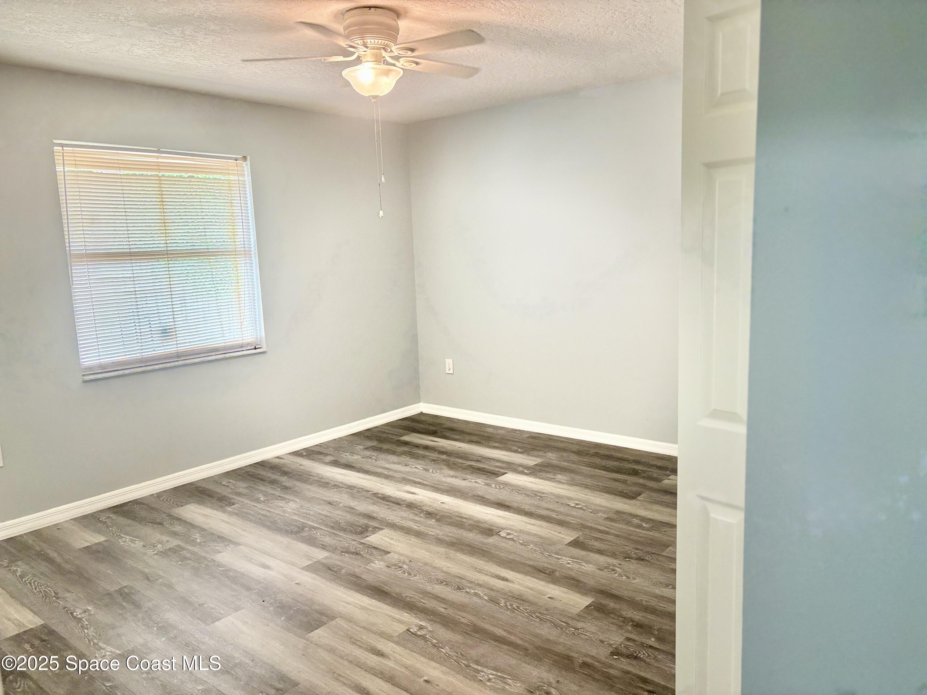704 Cavio Avenue Northeast Palm Bay, FL 32905 - Photo 14 of 17 a view of empty room with wooden floor