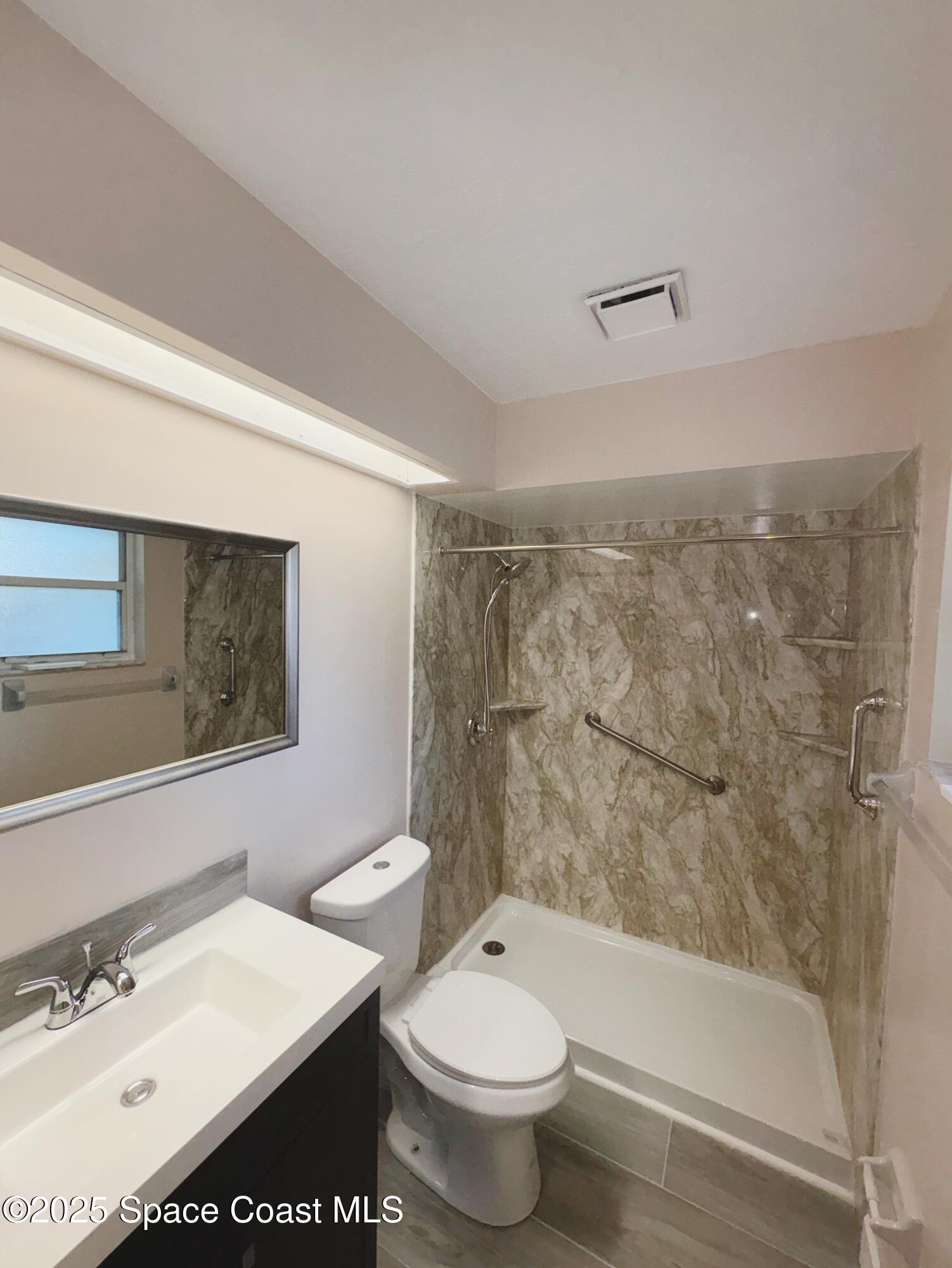 704 Cavio Avenue Northeast Palm Bay, FL 32905 - Photo 15 of 17 a bathroom with a sink a toilet and shower
