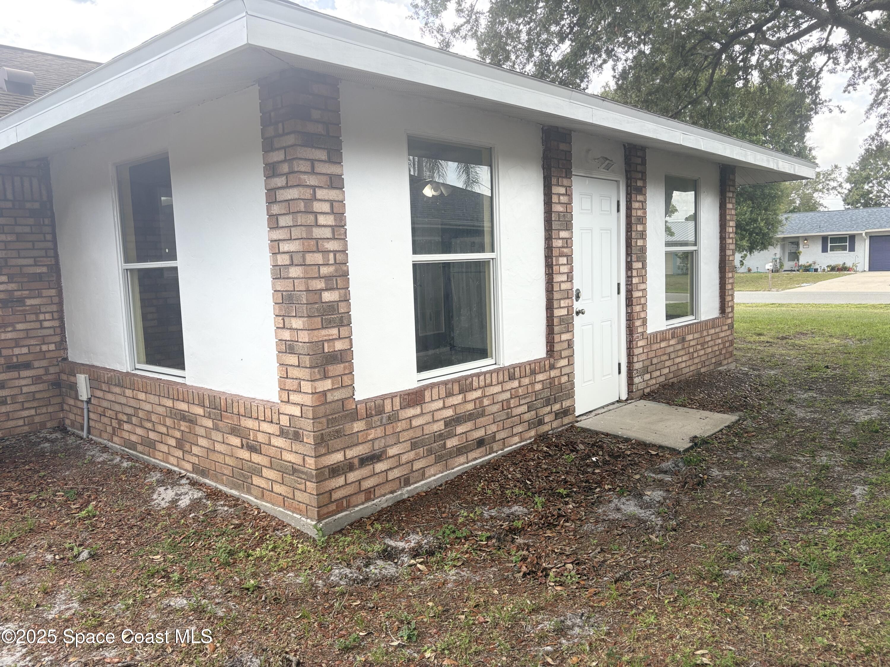 704 Cavio Avenue Northeast Palm Bay, FL 32905 - Photo 16 of 17 a front view of a house with a yard
