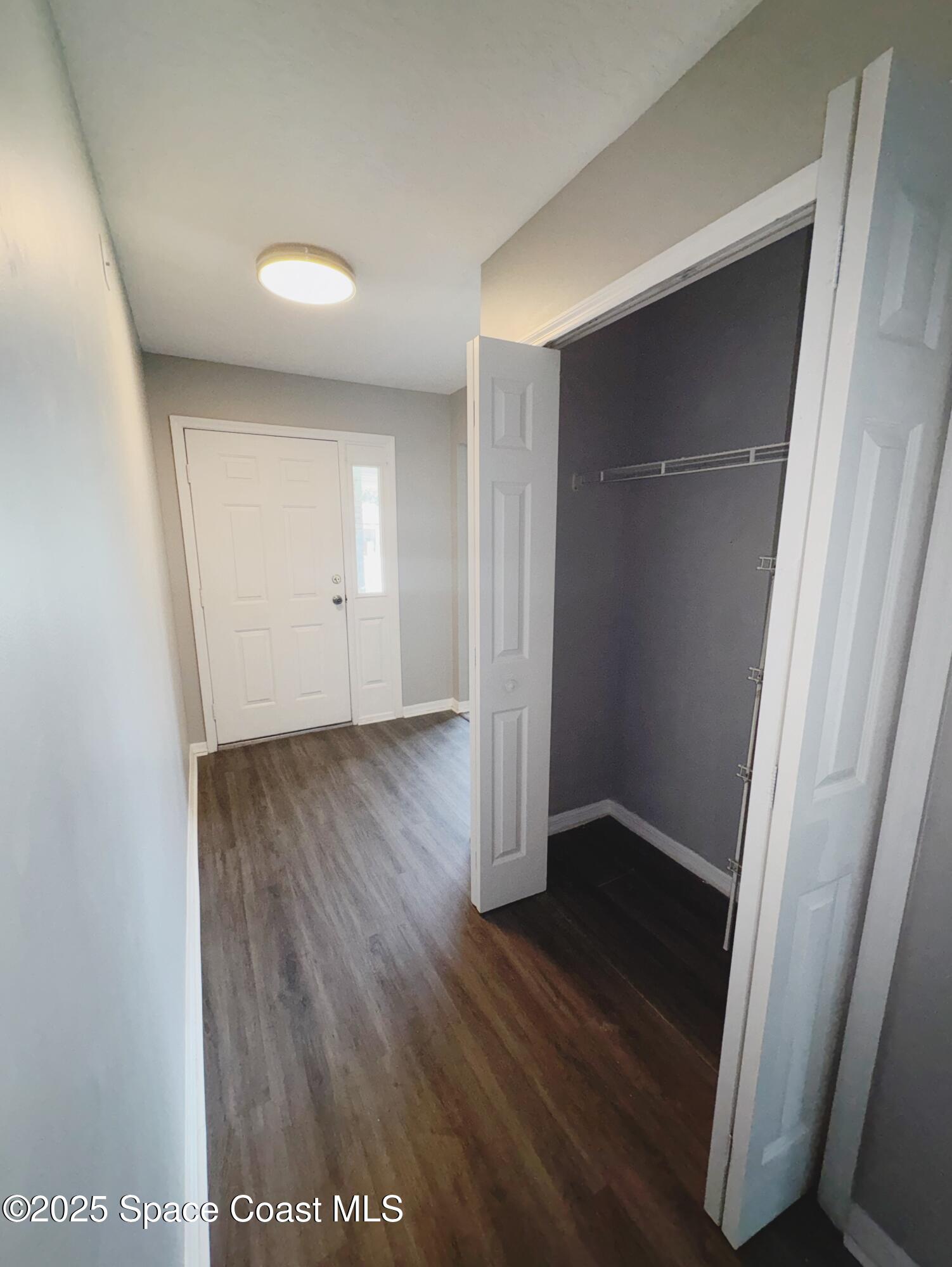 704 Cavio Avenue Northeast Palm Bay, FL 32905 - Photo 2 of 17 an empty room with wooden floor and closet