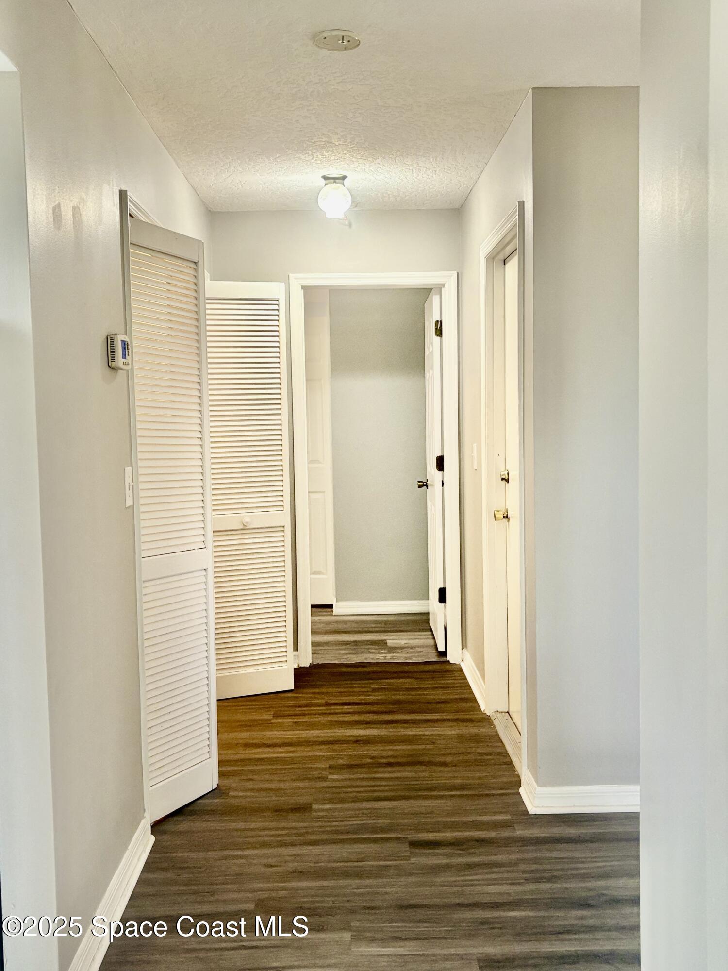 704 Cavio Avenue Northeast Palm Bay, FL 32905 - Photo 5 of 17 a view of a hallway with wooden floor and a bathroom