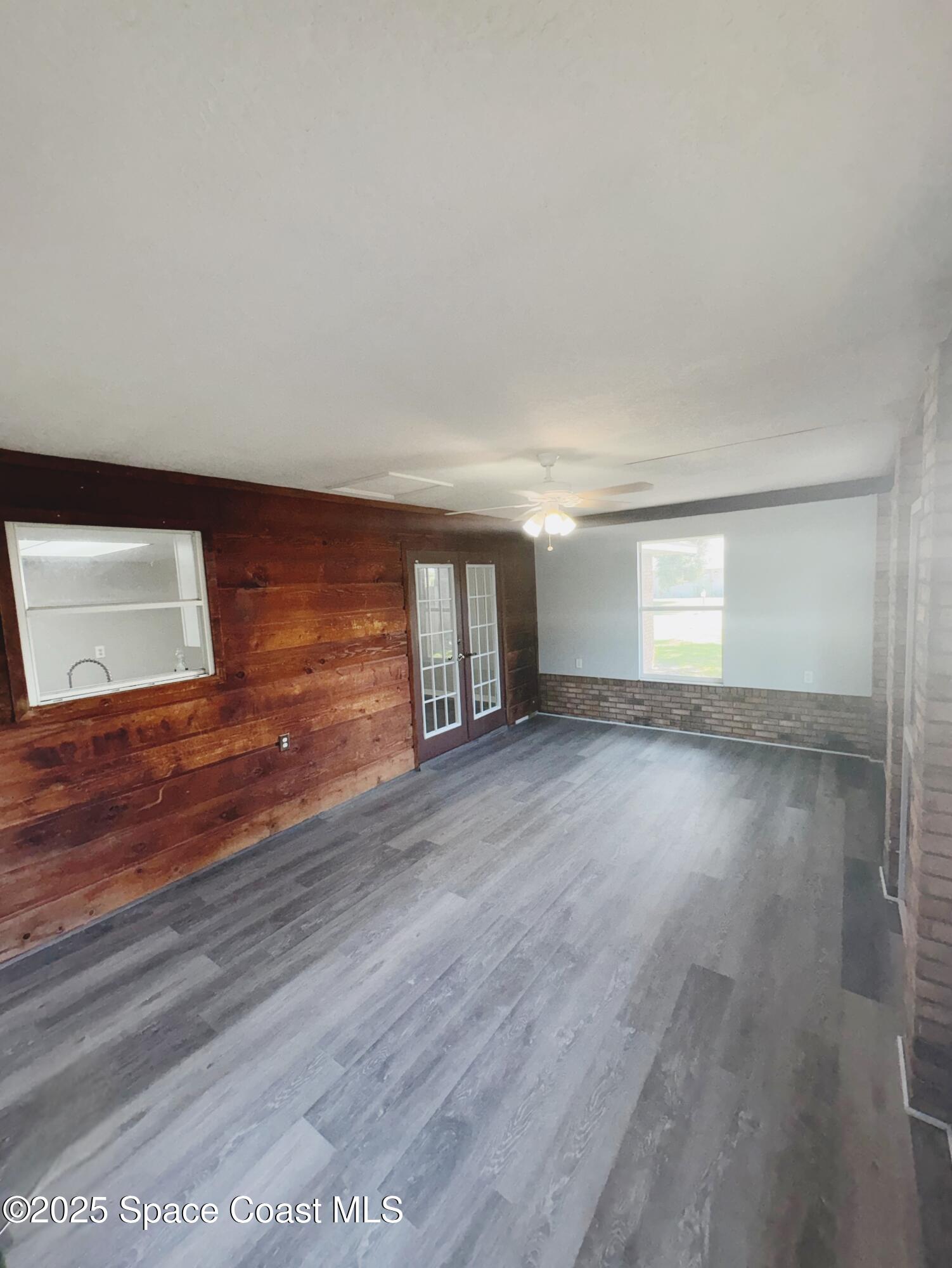 704 Cavio Avenue Northeast Palm Bay, FL 32905 - Photo 9 of 17 a view of empty room with wooden floor and fan