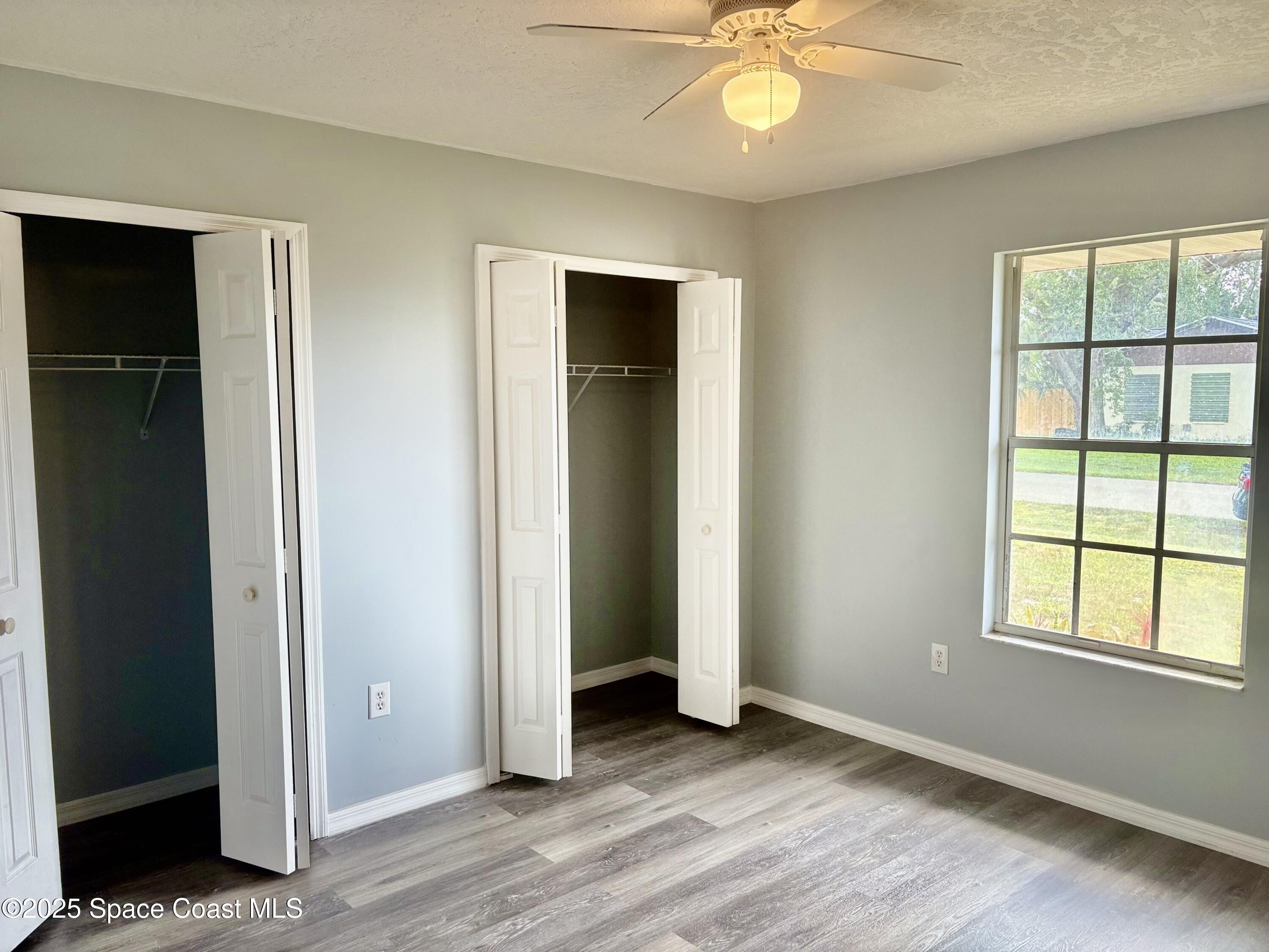 704 Cavio Avenue Northeast Palm Bay, FL 32905 - Photo 10 of 17 an empty room with wooden floor closet and windows