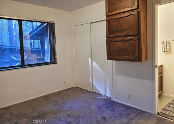 a view of an empty room with a window and a flat screen tv