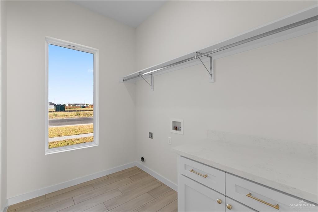 449 Padre Road Donna, TX 78537 - Photo 14 of 22 White cabinetry with gold-tone hardware, white countertop, tile flooring, and a large window