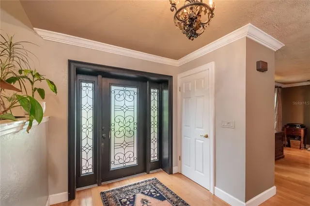 a view of a livingroom with a flat screen tv wooden floor and a ceiling fan