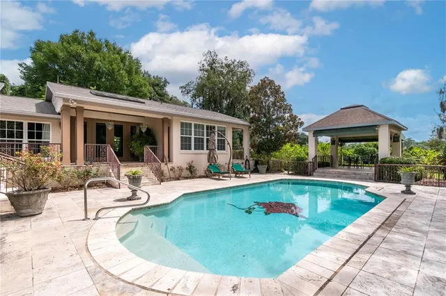 a view of a house with a yard and large tree