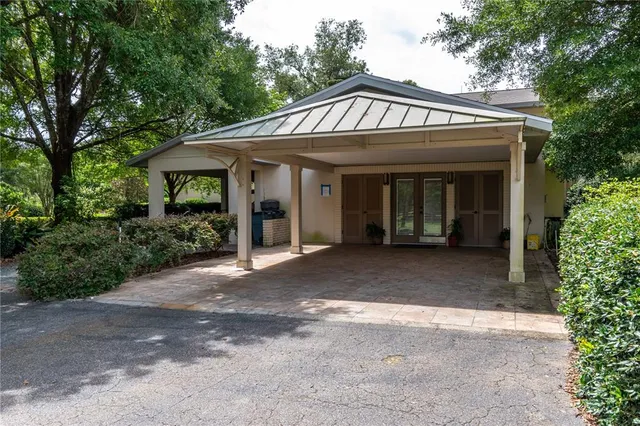 an aerial view of residential houses with outdoor space and trees all around