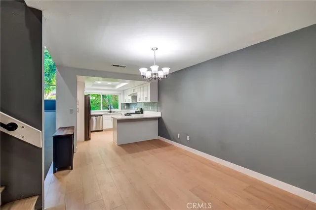 a view of an empty room with a chandelier fan