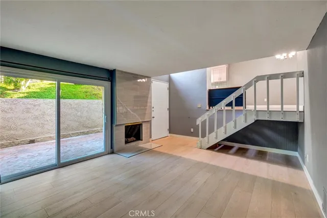 an empty room with wooden floor and a fireplace