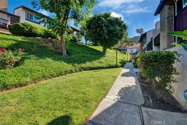a front view of a house with a yard and potted plants