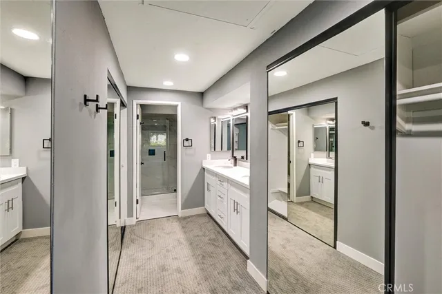 a bathroom with double vanity sinks and a large mirror
