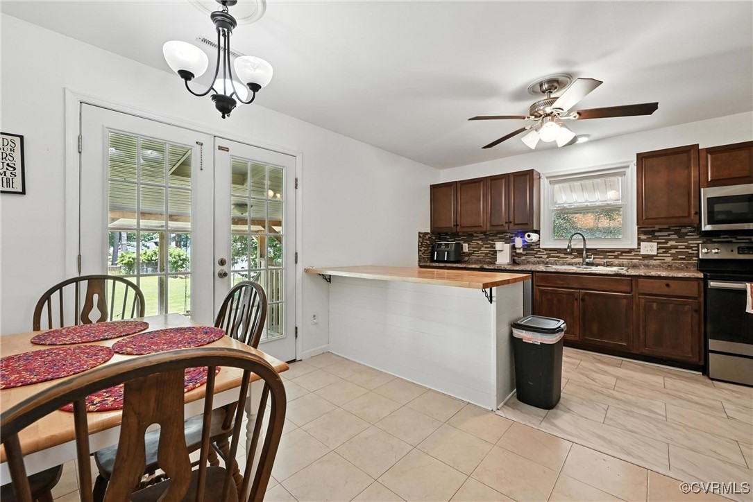 1593 Baxter Road Prince George, VA 23875 - Photo 6 of 48 a kitchen with a refrigerator a stove a sink a microwave and dining table